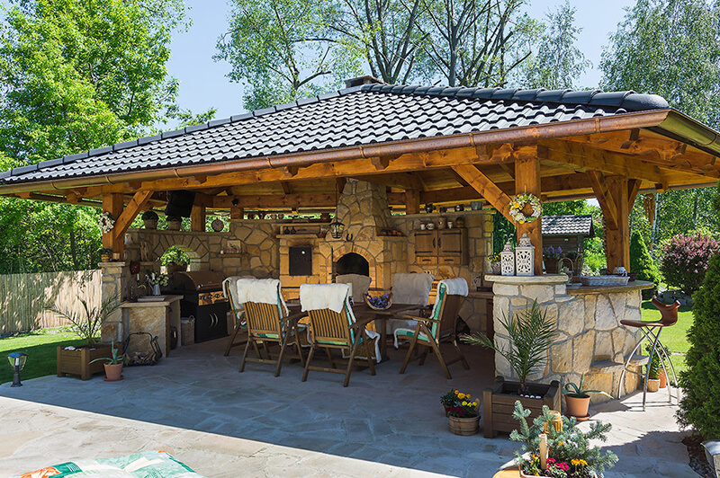 Dřevěná pergola s krbem, pecí a udírnou z kamene